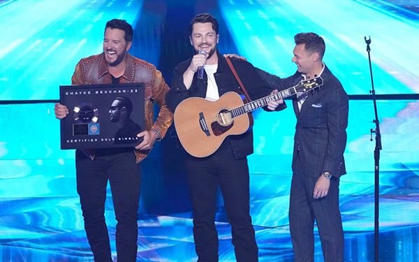 Chayce Beckham on stage celebrating with Lionel Ritchie